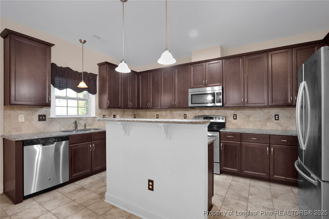 89 Revolutionary Road Cameron, NC 28326 - Photo 10 of 37 a kitchen with a sink a microwave and wooden cabinets