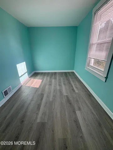 a view of wooden floor and windows in a room