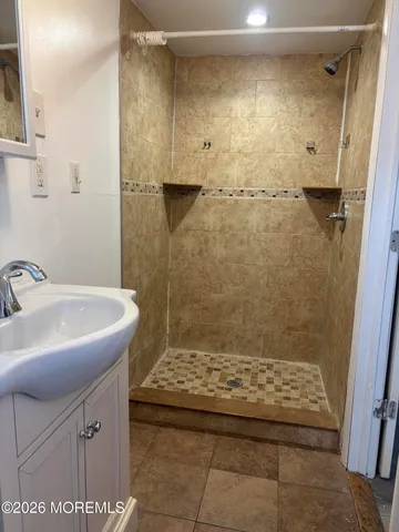 a bathroom with a sink a shower and a mirror