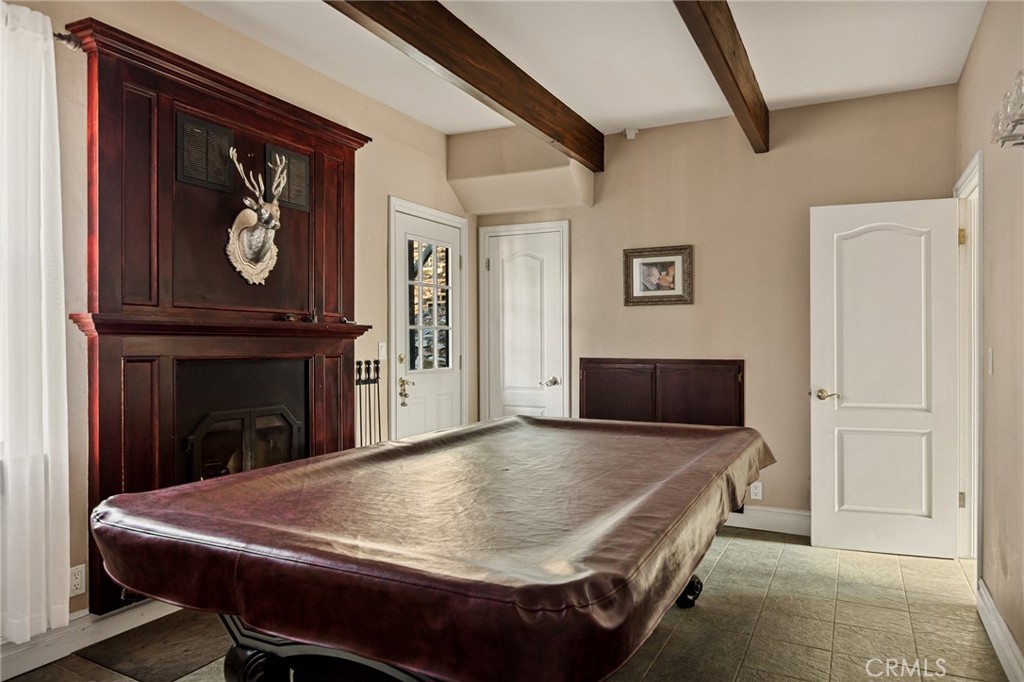 1055 Meadow Brook Road Lake Arrowhead, CA 92352 - Photo 17 of 27 a living room with furniture a clock and a fireplace