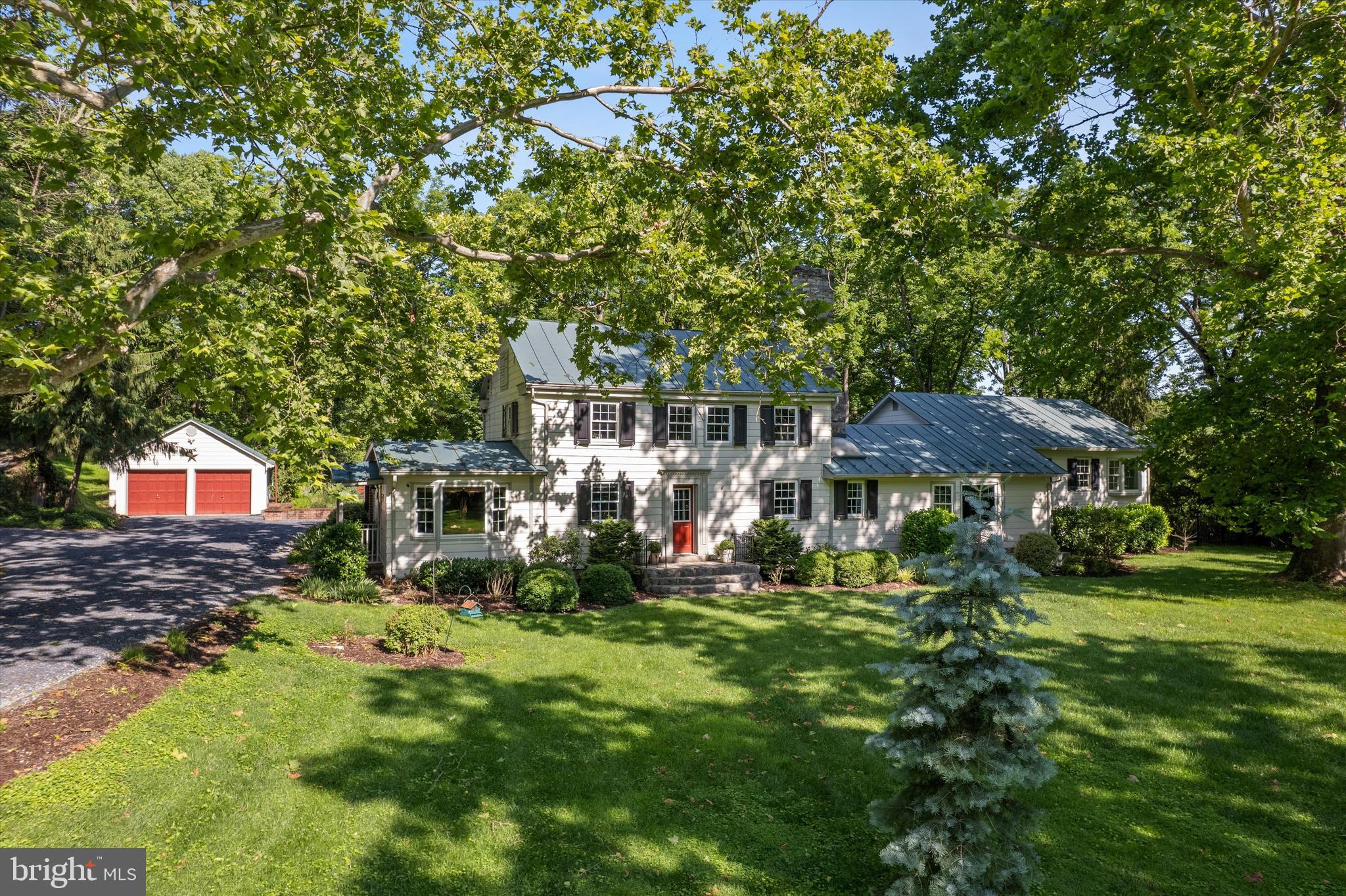 a view of a house with a big yard and large trees