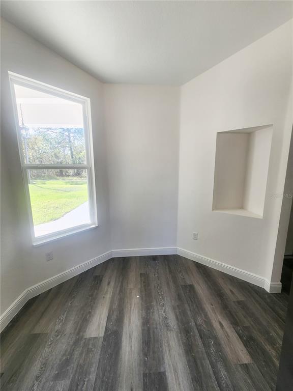 9483 Southwest 121st Terrace Dunnellon, FL 34432 - Photo 20 of 42 a view of an empty room with wooden floor and a window