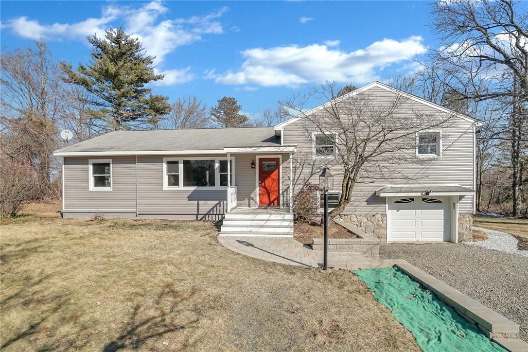 a view of a white house with a large tree