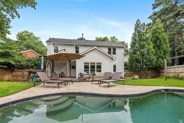 a view of a house with swimming pool and sitting area