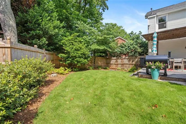 a view of a backyard with table and chairs and potted plants