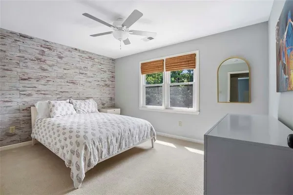 a bedroom with a bed lamp and a large window