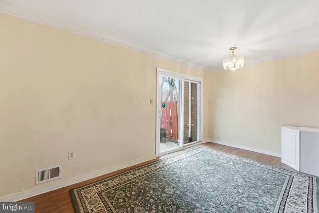 an empty room with a ceiling fan and a rug