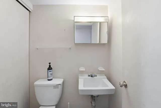 a bathroom with a toilet sink and mirror