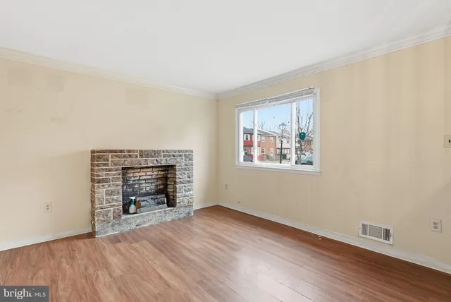 a view of empty room with wooden floor and fireplace