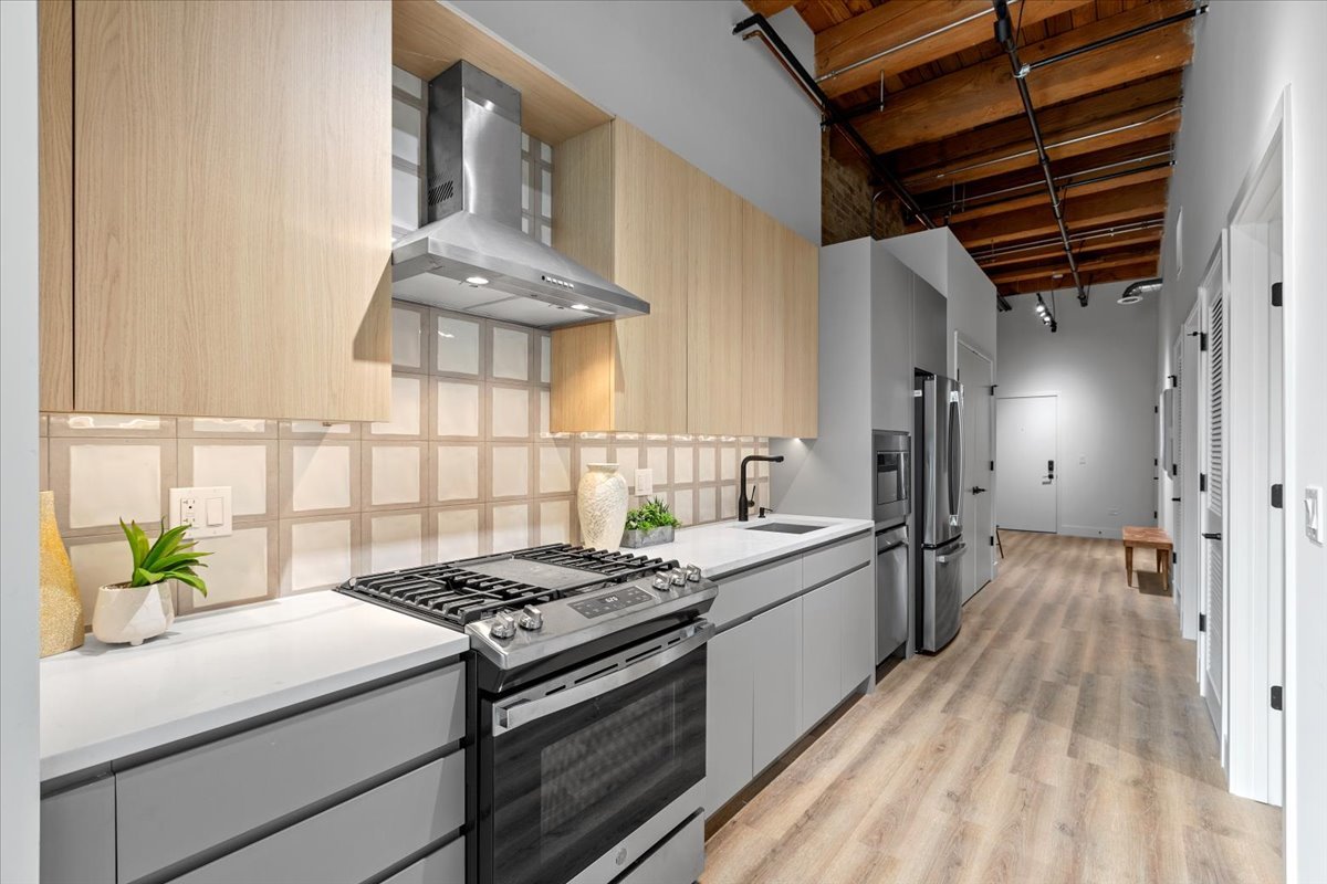 153 West Ohio Street, Unit 204 Chicago, IL 60654 - Photo 5 of 15 a kitchen with a stove and a white wooden cabinets
