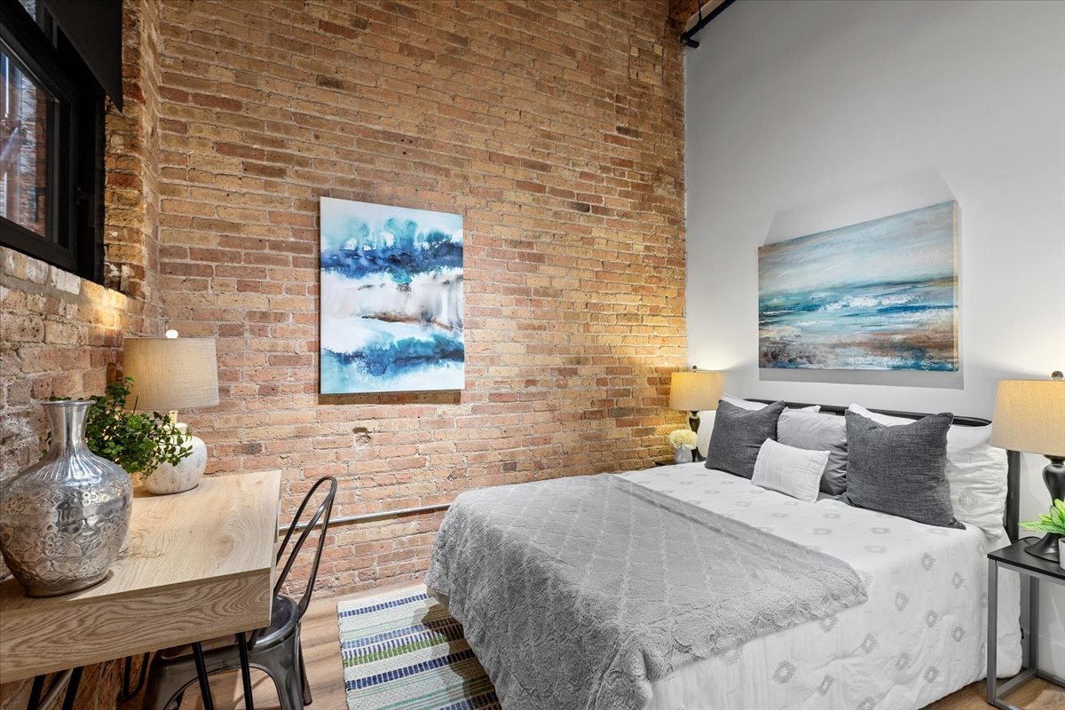 153 West Ohio Street, Unit 204 Chicago, IL 60654 - Photo 7 of 15 a bedroom with a bed and wall painting