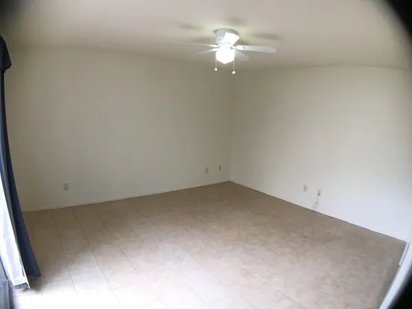 an empty room with a chandelier fan