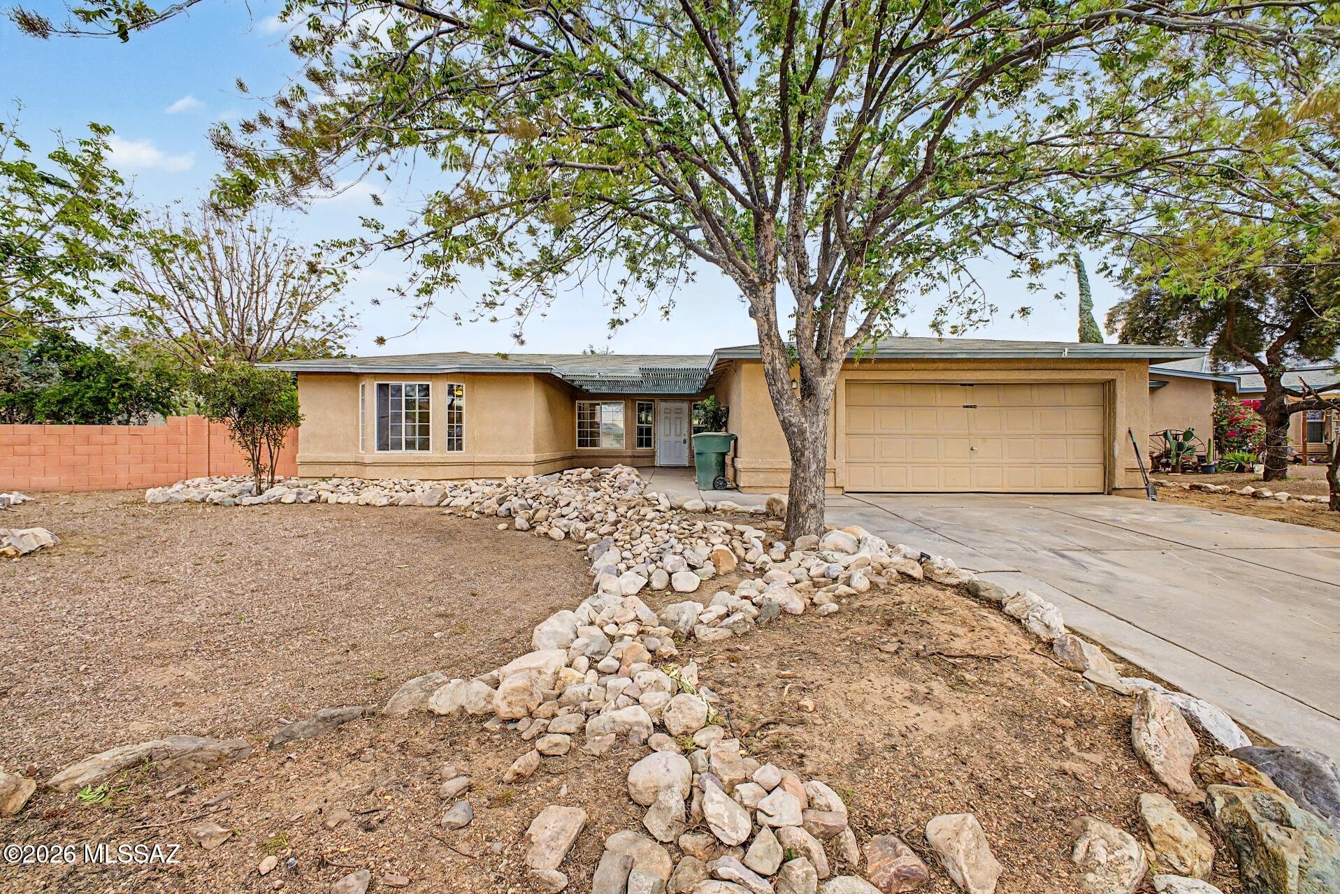 9810 East Stonehaven Way Tucson, AZ 85747 - Photo 2 of 27 front view of a house with a trees