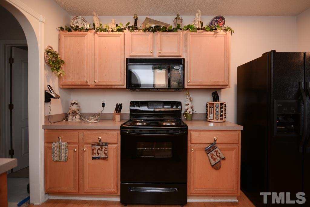 4601 Drewbridge Way Raleigh, NC 27604 - Photo 11 of 25 a kitchen with stainless steel appliances granite countertop a stove and a refrigerator