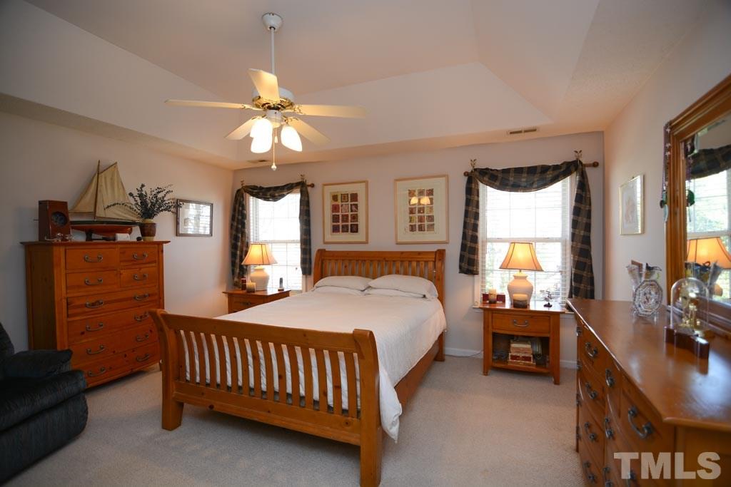 4601 Drewbridge Way Raleigh, NC 27604 - Photo 13 of 25 a bedroom with a bed and a chandelier