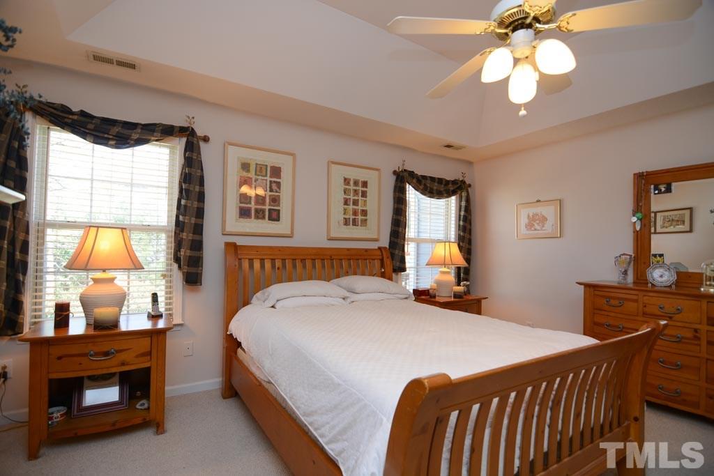 4601 Drewbridge Way Raleigh, NC 27604 - Photo 14 of 25 a bedroom with a bed and a chandelier