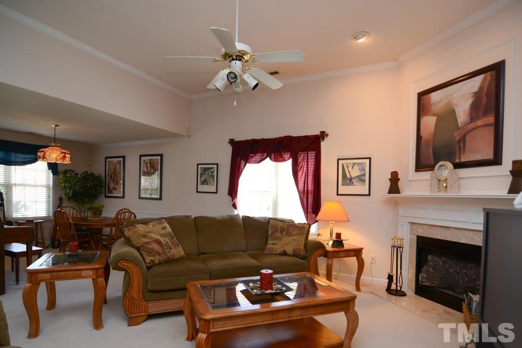 4601 Drewbridge Way Raleigh, NC 27604 - Photo 21 of 25 a living room with furniture a fireplace and a flat screen tv