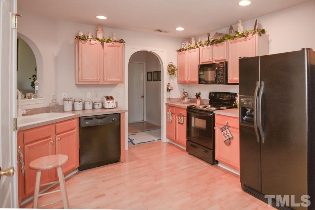 4601 Drewbridge Way Raleigh, NC 27604 - Photo 8 of 25 a kitchen with stainless steel appliances granite countertop a refrigerator sink and stove