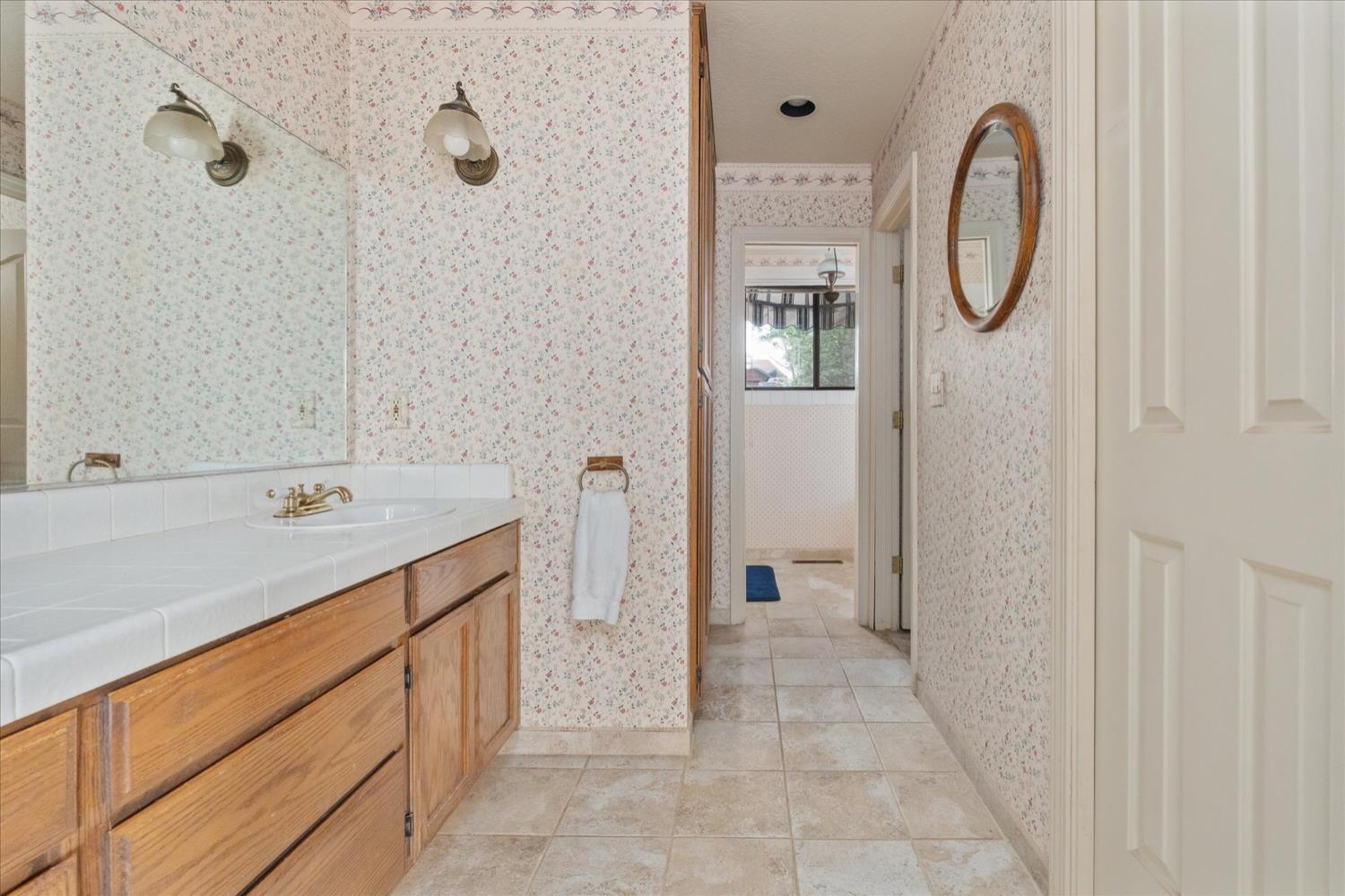 596 Sugarbush Lane Murphys, CA 95247 - Photo 26 of 48 a spacious bathroom with a granite countertop sink a mirror and a shower