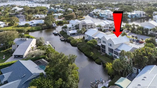 an aerial view of residential houses with outdoor space and lake view