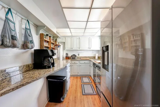 a kitchen with stainless steel appliances granite countertop a refrigerator and a sink
