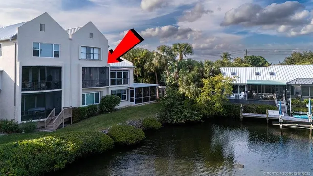 a aerial view of a house with a yard and a large tree in it