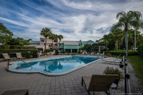 a view of a swimming pool with lawn chairs