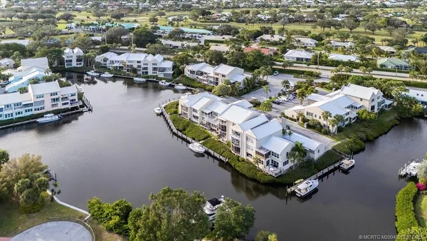 an aerial view of residential houses with outdoor space and lake view