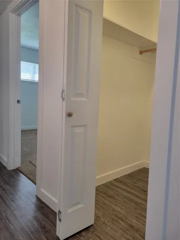 a view of a hallway with wooden floor