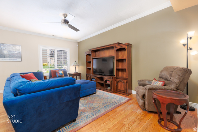 6761 950 East Midvale, UT 84047 - Photo 6 of 44 Living area featuring wood-finish flooring, a wood entertainment center with built-in shelving, and a ceiling fan