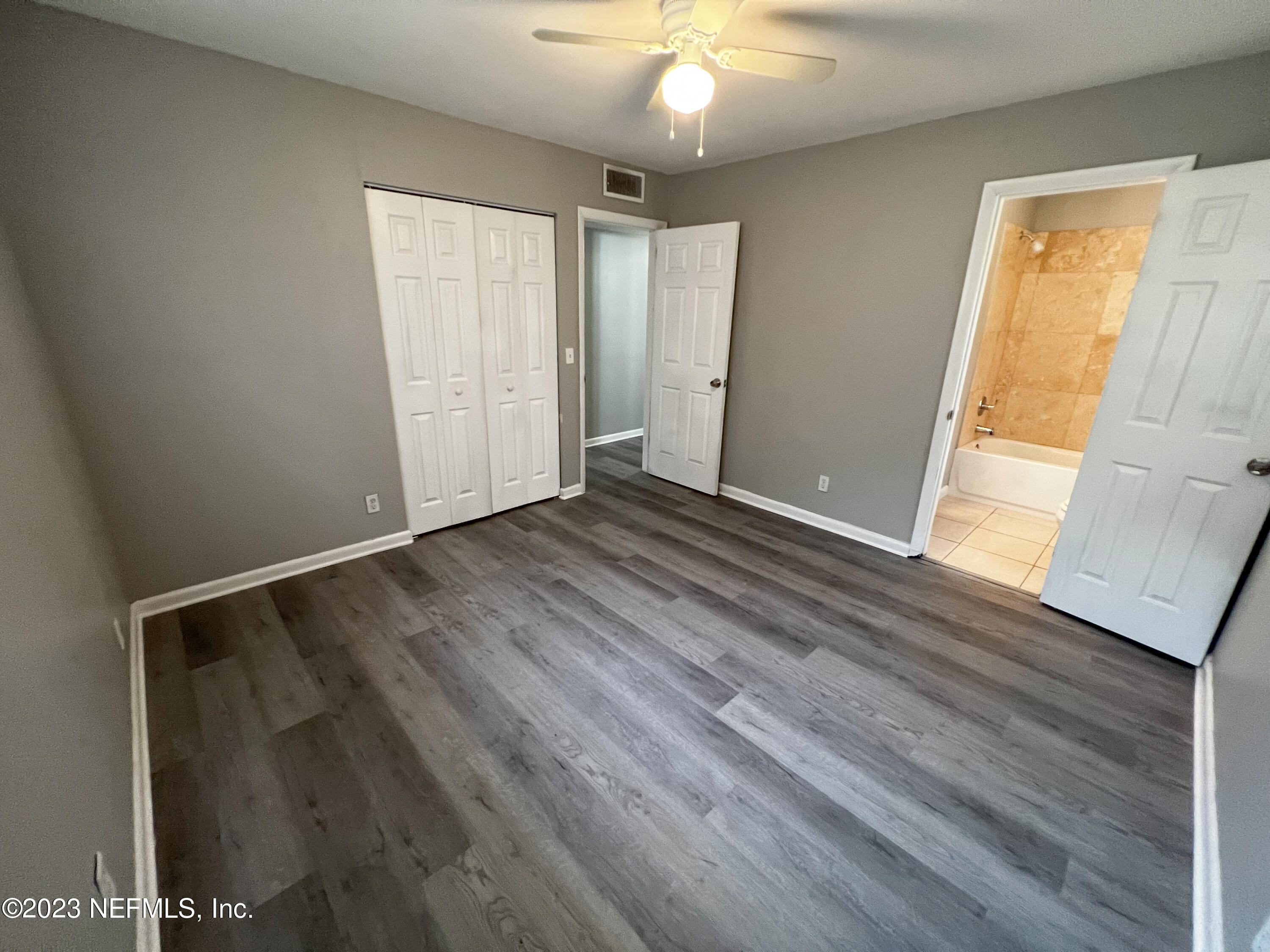 4719 Andromeda Road Jacksonville, FL 32210 - Photo 13 of 28 a view of an empty room with wooden floor and a window