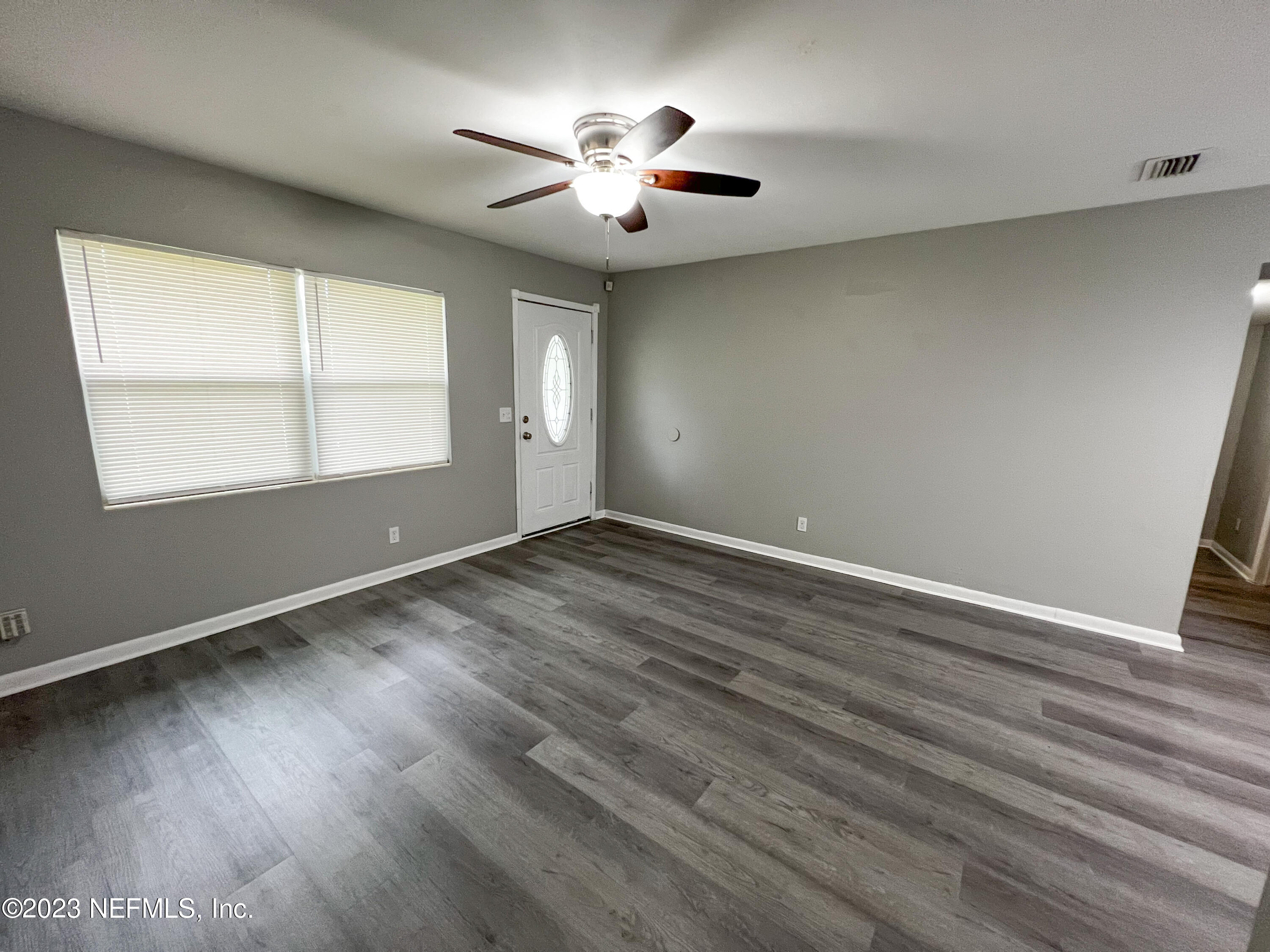 4719 Andromeda Road Jacksonville, FL 32210 - Photo 3 of 28 an empty room with wooden floor and windows
