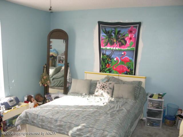 4200 South Jackson Street Amarillo, TX 79110 - Photo 3 of 8 a bed sitting in a bedroom next to a painting on the wall