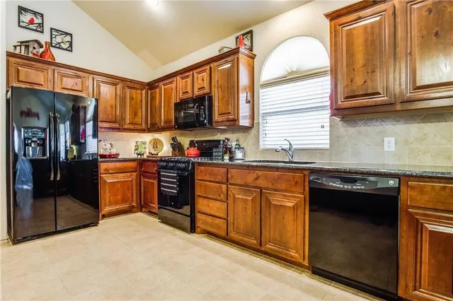 a kitchen with stainless steel appliances granite countertop a stove sink microwave and cabinets