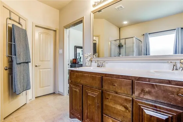 a bathroom with a double vanity sink a mirror and a shower