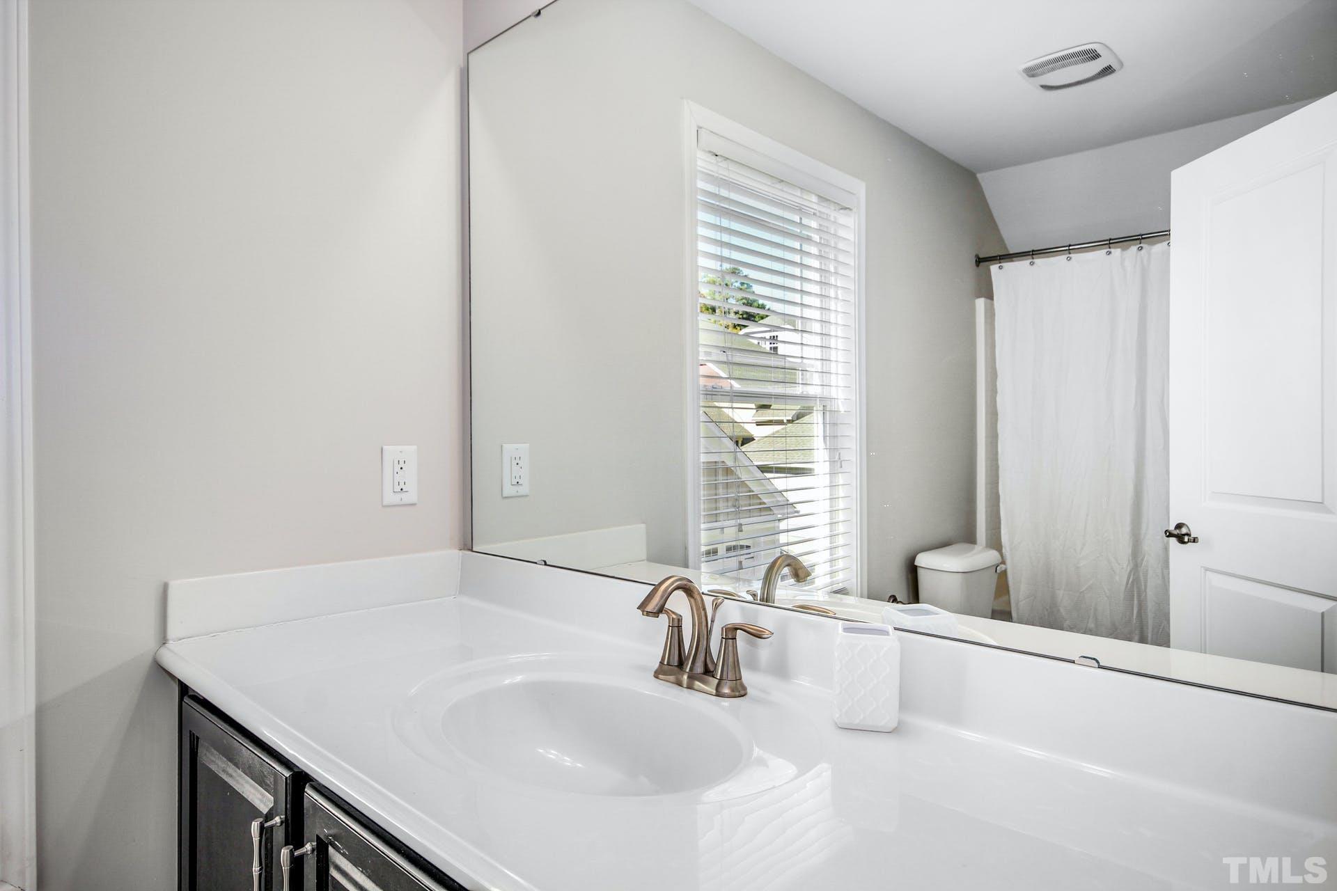1524 Rodessa Run Raleigh, NC 27607 - Photo 22 of 25 a bathroom with a sink and a large mirror