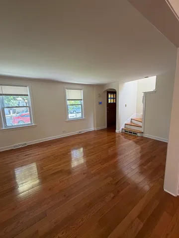 a view of a livingroom with wooden floor and a ceiling fan