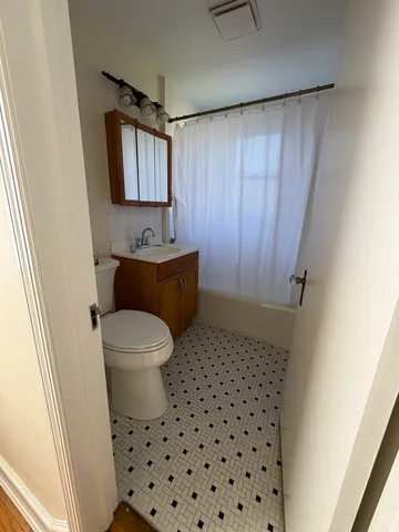 a bathroom with a sink a toilet a mirror and shower