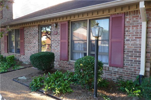705 Kent Road, Unit 705 Nashville, TN 37214 - Photo 1 of 6 a view of a brick house with a large windows and flower plants