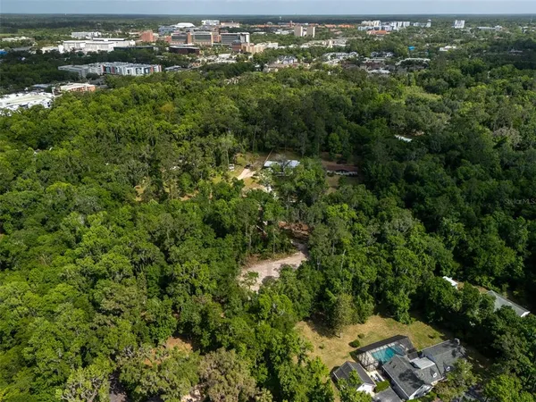 an aerial view of residential houses with outdoor space and trees