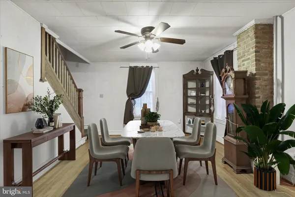 a dining room with furniture potted plants and wooden floor