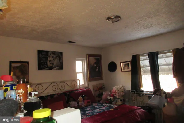 a bedroom with a bed and a dresser next to a window