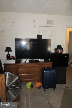 a living room with stainless steel appliances kitchen island furniture and a flat screen tv