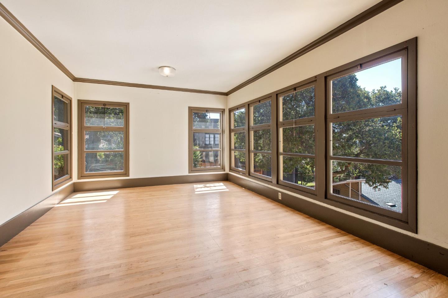 585 Santa Rosa Avenue Berkeley, CA 94707 - Photo 19 of 71 a view of an empty room with a window and wooden floor