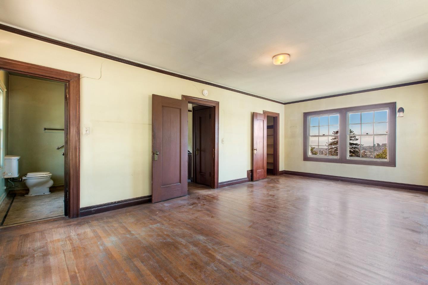 585 Santa Rosa Avenue Berkeley, CA 94707 - Photo 35 of 71 an empty room with wooden floor and windows