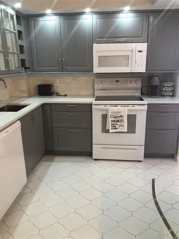 a kitchen with a stove sink and cabinets