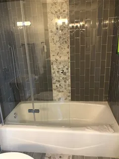 a bathroom with a bathtub and shower