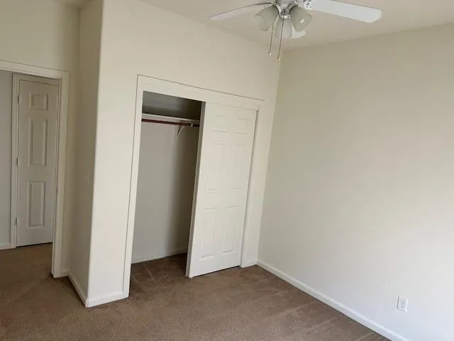 a view of an empty room with a ceiling fan