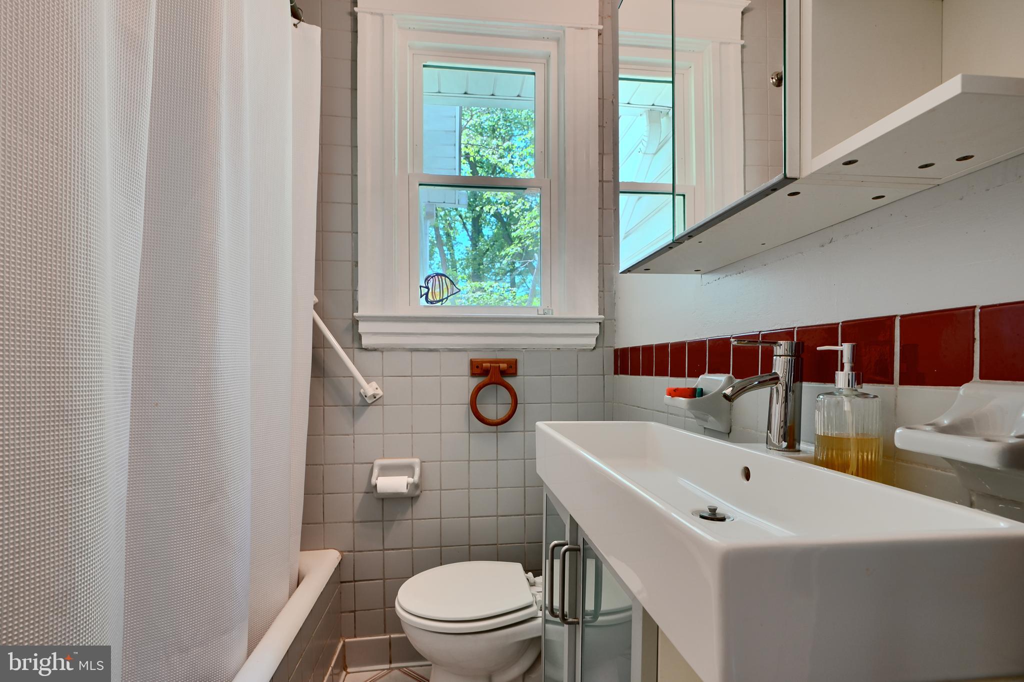 1111 Overbrook Road Baltimore, MD 21239 - Photo 22 of 47 a bathroom with a sink a toilet and shower curtain