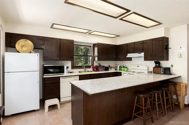 a kitchen with a sink a stove a refrigerator and cabinets